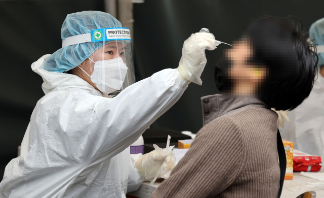 18일 서울역 광장에 마련된 코로나19 임시 선별검사소에서 의료진이 검체를 채취하고 있다. 연합뉴스
