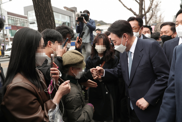 윤석열 대통령 당선인이 18일 국민의힘 이준석 대표, 김기현 원내대표, 정진석 국회부의장과 서울 종로구 인수위 인근에서 오찬을 마치고 산책하며 시민들과 인사하고 있다. 연합뉴스
