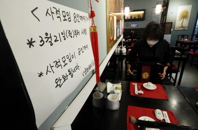 20일 서울 양천구의 한 중식당에 21일부터 시행되는 사회적 거리두기 조정 관련 8인 단체손님 입장이 가능하다는 내용의 안내문이 부착돼 있다. 중앙재난안전대책본부에 따르면, 21일부터 사회적 거리두기 일부 완화로 사적모임은 지역이나 접종 여부와 관계없이 8명까지 가능해진다. 연합뉴스