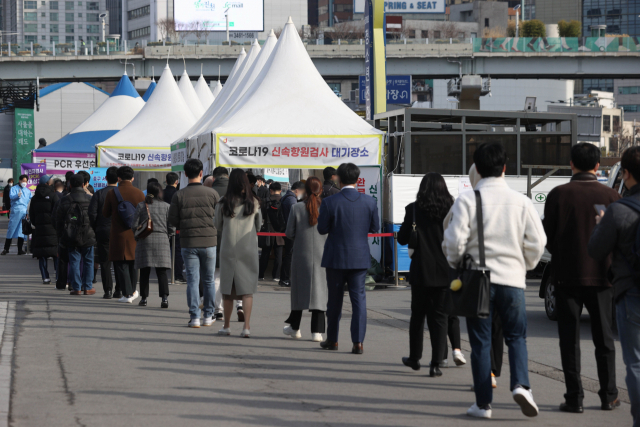 21일 오전 서울역 선별진료소에서 의료진이 시민들을 안내하고 있다. 중앙방역대책본부는 21일 0시 기준 코로나19 신규 확진자가 20만9,169명 집계됐다고 밝혔다. 연합뉴스