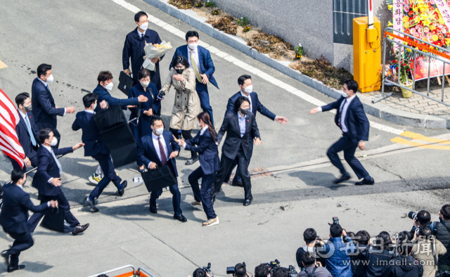 10년 만에 대구로 귀향한 박근혜 전 대통령이 24일 대구 달성군 유가읍 사저 앞에서 인사말을 하던 중 소주병이 날아와 경호원들이 박 전 대통령을 에워싸고 있다. 안성완 기자 asw0727@imaeil.com