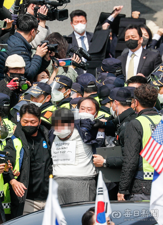 24일 낮 대구 달성군 사저에 도착한 박근혜 전 대통령을 향해 소주병을 던진 남성이 경찰에 연행되고 있다. 우태욱 기자 woo@imaeil.com