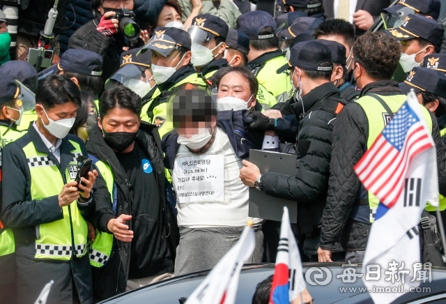 24일 낮 대구 달성군 사저에 도착한 박근혜 전 대통령을 향해 소주병을 던진 남성이 경찰에 연행되고 있다. 우태욱 기자 woo@imaeil.com