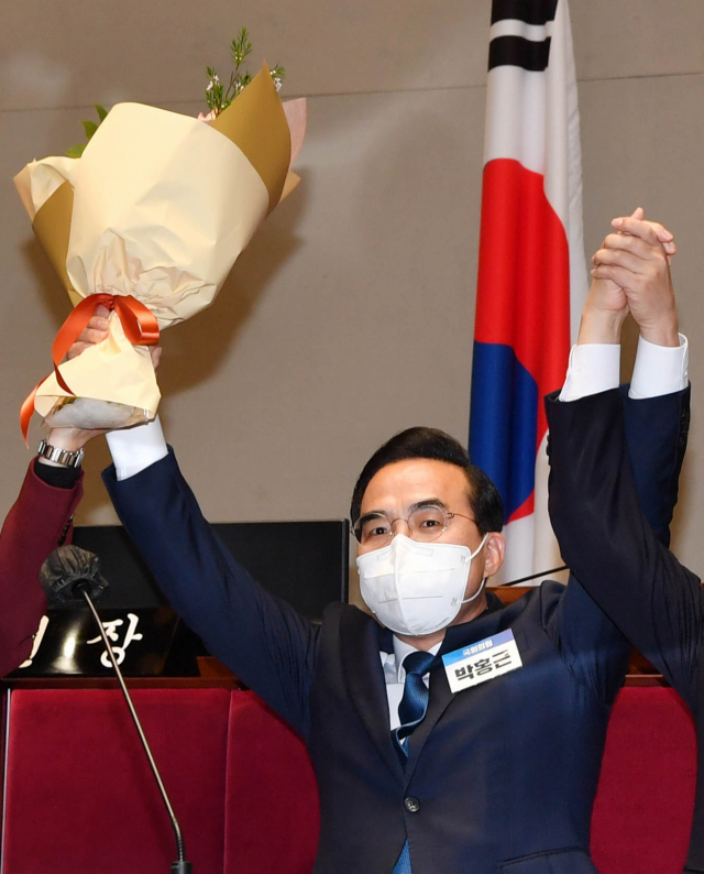 더불어민주당 박홍근 신임 원내대표가 24일 국회에서 열린 의원총회에서 새로운 원내대표 선출된 뒤 꽃다발을 들어 올리고 있다. 연합뉴스