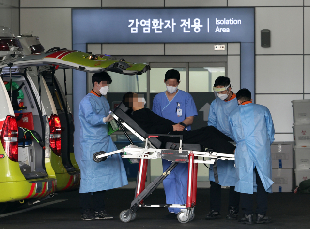 20일 중랑구 서울의료원에서 의료진이 코로나19 환자를 옮기고 있다. 연합뉴스