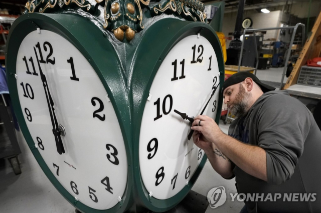 미국 매사추세츠주 메드필드에 있는 일렉트릭 타임 컴퍼니에서 한 시계공이 제작 단계에 있는 대형 옥외용 시계의 시침과 분침을 조정하고 있다. 연합뉴스