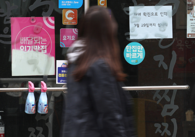 오미크론 변이 대유행이 이어지면서 신규 확진자수가 40만명에 육박한 가운데 24일 오후 서울시내 한 식당 유리문에 자녀 확진으로 인한 휴무 안내문이 붙어 있다. 연합뉴스