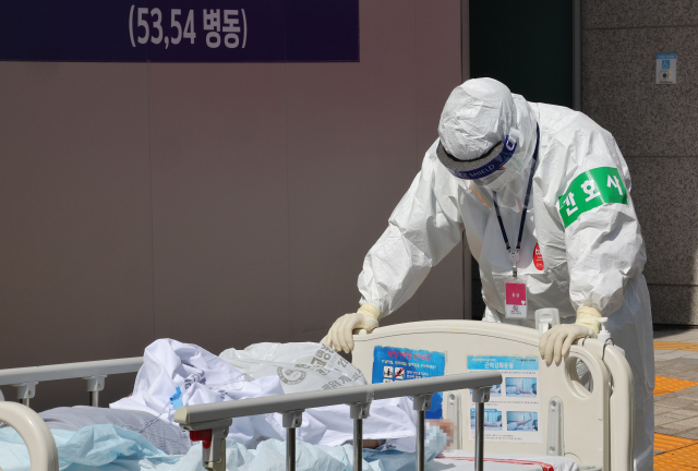 신규 코로나19 확진자가 다시 30만명대로 올라선 29일 서울 은평구 서북병원에서 의료진이 코로나19 환자를 옮기고 있다. 연합뉴스