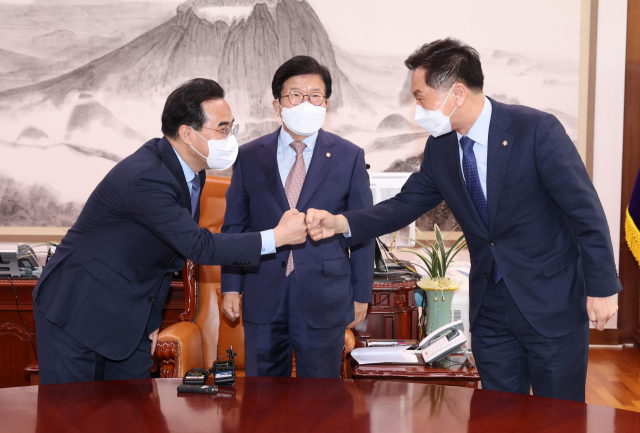 30일 오전 국회에서 박병석 국회의장 주재로 열린 양당 원내대표 회동에서 더불어민주당 박홍근 원내대표와 국민의힘 김기현 원내대표가 주먹 인사를 하고 있다. 연합뉴스