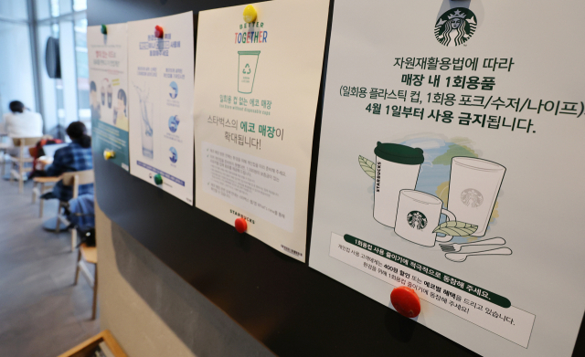 31일 서울 중구의 한 프랜차이즈 커피 매장 게시판에 자원재활용법에 따른 매장 내 일회용품 사용 제한 안내문이 부착돼 있다. 신종 코로나바이러스 감염증 등을 이유로 한시적으로 허용됐던 카페 등 식품접객업 매장 내 일회용품 사용이 4월 1일부터 다시 제한된다. 환경부는 카페·식당 등 식품접객업 매장 내 일회용품 사용 제한에 대해 과태료 부과 등 단속 대신 지도와 안내 중심의 계도를 진행한다. 연합뉴스