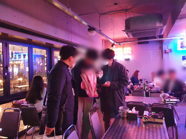지난달 17일 민관협력 청소년 유해환경감시단이 동성로 술집에서 한 남성에게 신분증 검사를 하고 있다. 배주현 기자