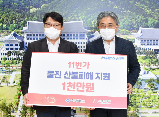 이진우 11번가 그룹장이 8일 울진 산불피해 지원금을 전달하며 강성조(오른쪽) 경북도 행정부지사와 기념촬영을 하고 있다. 경북도 제공
