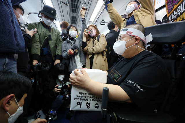 30일 오전 전국장애인차별철폐연대의 장애인권리예산 및 관련법 개정 요구에 대한 인수위 답변 촉구 삭발 투쟁 결의식을 마친 이형숙 서울시장애인자립생활센터협의회장이 서울 혜화역에서 선전전을 하기 위해 지하철로 이동하고 있다. 연합뉴스