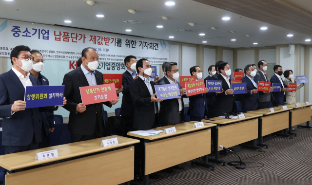 김기문 중소기업중앙회장(가운데)과 대한기계설비건설협회, ㈔한국창호커튼월협회 등 18개 중소기업 단체 관계자들이 11일 서울 여의도 중소기업중앙회에서 열린 중소기업 납품단가 제값받기를 위한 기자회견에서 납품단가 연동제 도입, 대통령 직속 상생위원회 설치를 촉구하며 구호를 외치고 있다. 연합뉴스