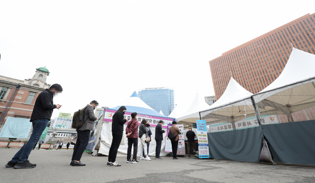코로나19 선별진료소와 임시선별검사소 신속항원검사 중단 이틀째인 12일 오전 서울역광장에 마련된 임시선별검사소를 찾은 시민들이 PCR 검사를 기다리고 있다. 한편 중앙방역대책본부에 따르면 이날 신규확진자 수는 21만755명으로 집계됐다. 연합뉴스
