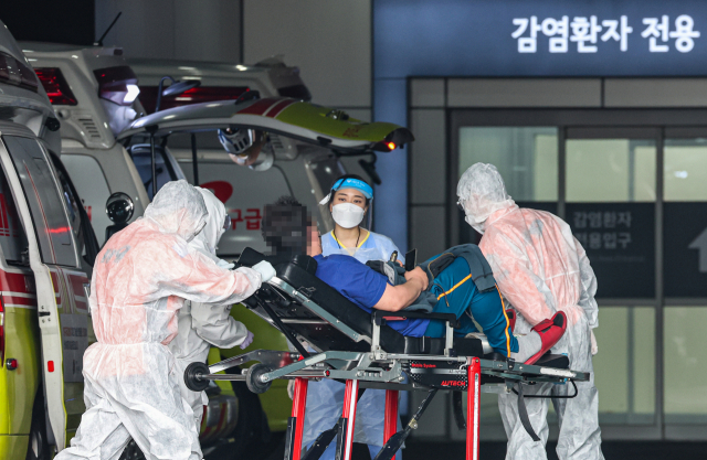 서울 중랑구 서울의료원에서 119 구급대원과 의료진이 병원에 도착한 환자를 감염병 전문 병동으로 이송하고 있다. 연합뉴스