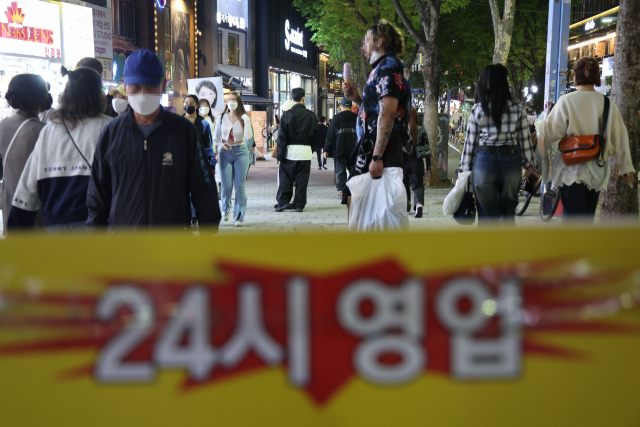 코로나19 사회적 거리두기 해제를 하루 앞둔 17일 오후 서울 마포구 홍대입구역 인근에서 시민들이 걸어가고 있다. 연합뉴스