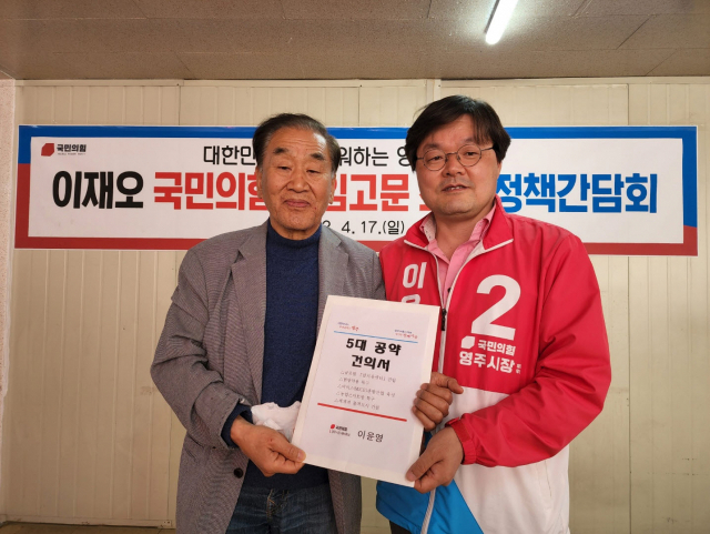이윤영 국민의힘 영주시장 예비후보가 5대 공약 건의서를 이재오 국민의힘 상임고문에게 전달하고 있다. 이윤영 선거사무소 제공
