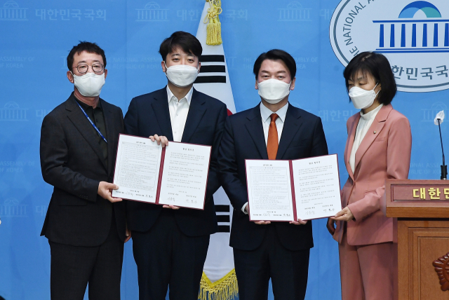 국민의힘 이준석 대표와 안철수 국민의당 대표가 18일 서울 여의도 국회 소통관에서 기자회견을 열고 합당을 선언한 뒤 합의문을 들어 보이고 있다. 왼쪽부터 홍철호 국민의힘 전략기획부총장, 이 대표, 안 대표, 최연숙 국민의당 사무총장. 연합뉴스