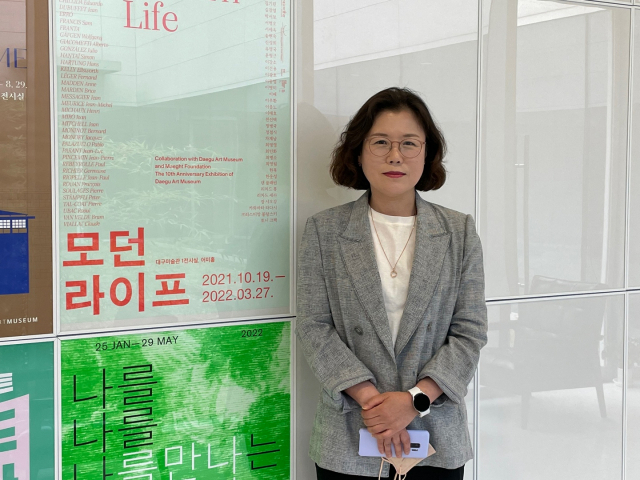 박민영 대구미술관 수집연구팀장이 전시 포스터 앞에서 포즈를 취하고 있다. 이연정 기자