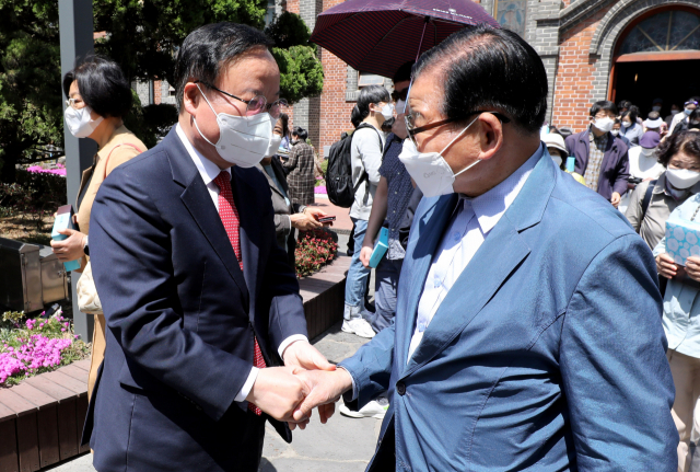 김재원(왼쪽) 국민의힘 대구시장 예비후보가 지난 17일 대구 계산성당에서 시민들과 인사를 나누고 있다. 김영진 기자 kyjmaeil@imaeil.com