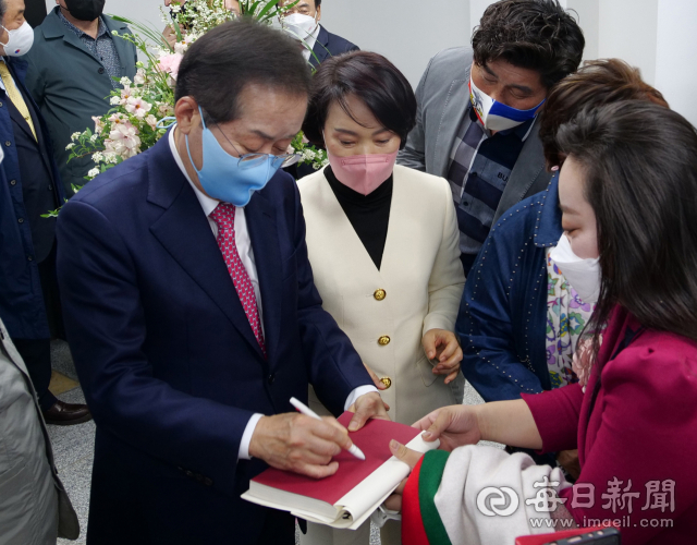 홍준표 국민의힘 대구시장 예비후보가 지난 16일 대구 중구 선거사무소 개소식에서 자신의 저서를 들고온 지지자에게 사인을 하고 있다. 홍준표 예비후보 캠프 제공