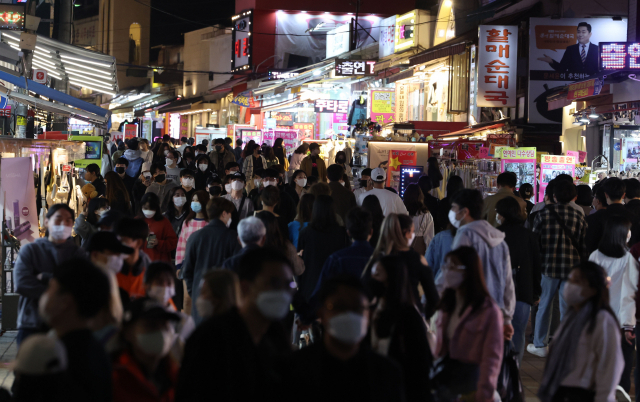 코로나19 사회적 거리두기 해제를 하루 앞둔 17일 오후 서울 마포구 홍대입구역 인근에서 시민들이 걸어가고 있다. 연합뉴스