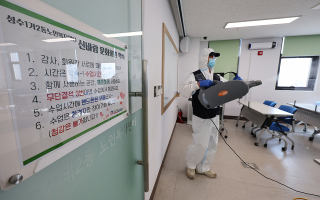 오미크론 변이 확산에 따라 운영이 전면 중단된 노인복지관, 경로당이 3차 접종자들을 대상으로 다시 문을 연다. 19일 오후 서울 성동구 성수1가2동 노인복지센터에서 관계자가 방역 작업을 하고 있다. 연합뉴스