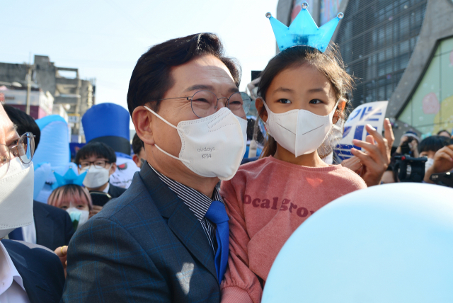 더불어민주당 송영길 전 대표가 17일 서울 마포구 홍대 상상마당 광장에서 6.1 지방선거 서울시장 출마 선언 기자회견을 마치고 한 어린이를 안고 있다. 연합뉴스