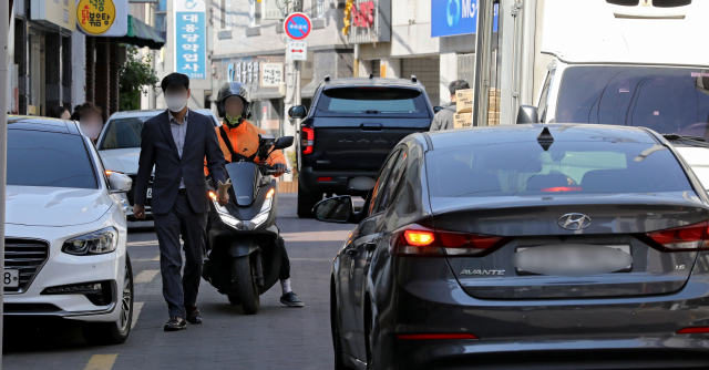 보행자 권한을 강화한 개정된 도로교통법이 시행된 20일 오후 대구 중구의 차,보도 구분없는 이면도로에서 사람과 차량들이 뒤엉켜 길을 지나고 있다. 김영진 기자 kyjmaeil@imaeil.com