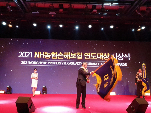 김상율 포항축산농협 조합장이 21일 서울에서 열린 2021 NH농협손해보험 연도대상 시상식에서 대상기를 힘차게 흔들고 있다. 포항축산농협 제공