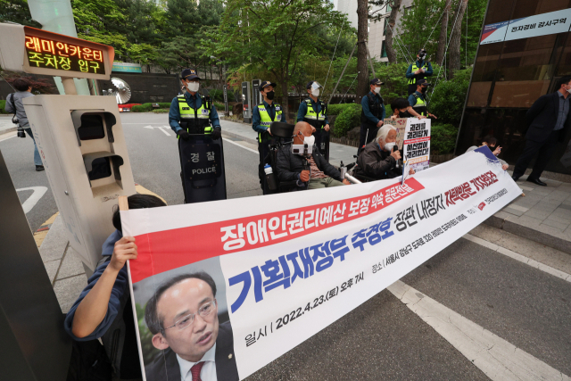 박경석 전국장애인차별철폐연대(전장연) 공동대표가 23일 오후 서울 강남구 레미안 도곡카운티 아파트 단지 입구에 설치된 주차 차단기 앞에서 추경호 경제부총리 겸 기획재정부 장관 후보자에게 장애인 권리예산 보장 약속 공문 전달을 하기 앞서 기자회견을 하고 있다. 연합뉴스