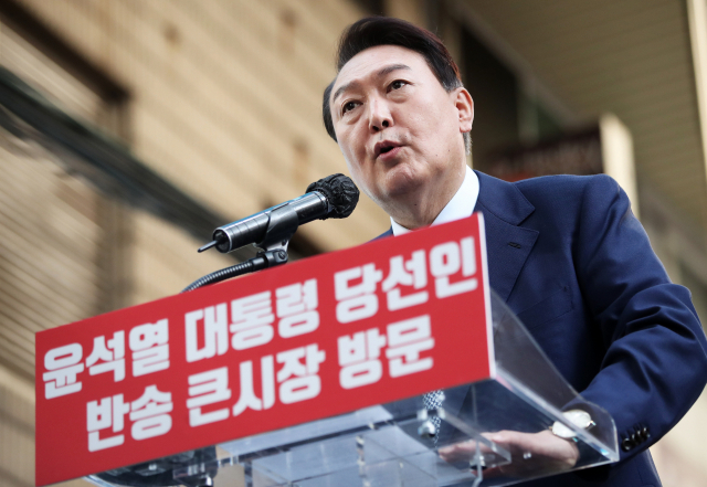 윤석열 대통령 당선인이 22일 부산 해운대구 반송큰시장을 방문해 시민들에게 감사 인사를 하고 있다. 연합뉴스