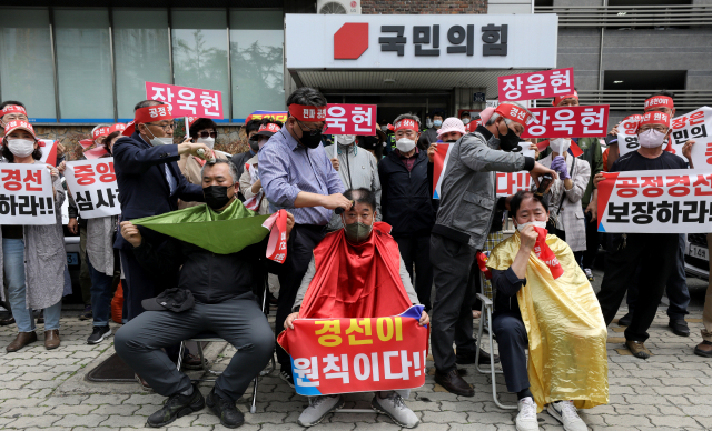 지난달 25일 오후 대구 수성구 국민의힘 경북도당 앞에서 현역 단체장인 이강덕 포항시장, 장욱현 영주시장, 김영만 군위군수에 대한 경북도당 공천관리위원회의 6·1지방선거 컷오프 결정에 항의하는 지지자들의 항의 삭발식이 진행되고 있다. 김영진 기자 kyjmaeil@imaeil.com