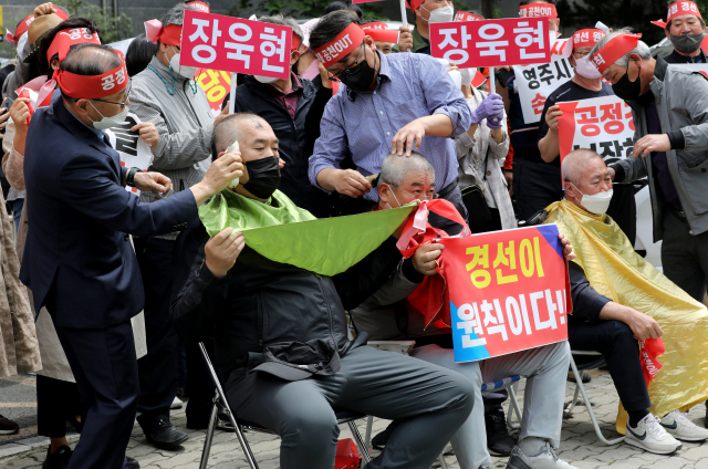 25일 오후 대구 수성구 국민의힘 경북도당 앞에서 현역 단체장인 이강덕 포항시장, 장욱현 영주시장, 김영만 군위군수에 대한 경북도당 공천관리위원회의 6·1지방선거 컷오프 결정에 항의하는 지지자들의 항의 삭발식이 진행되고 있다. 김영진 기자 kyjmaeil@imaeil.com