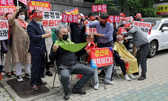 25일 오후 대구 수성구 국민의힘 경북도당 앞에서 현역 단체장인 이강덕 포항시장, 장욱현 영주시장, 김영만 군위군수에 대한 경북도당 공천관리위원회의 6·1지방선거 컷오프 결정에 항의하는 지지자들의 항의 삭발식이 진행되고 있다. 김영진 기자 kyjmaeil@imaeil.com