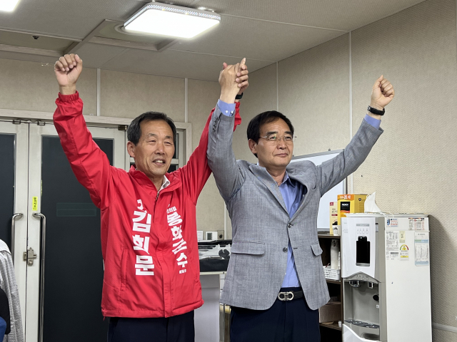 경선 불참을 선언한 김동룡 예비후보(오른쪽)가 종친인 김희문 예비후보의 손을 들어주고 있다. 마경대 기자