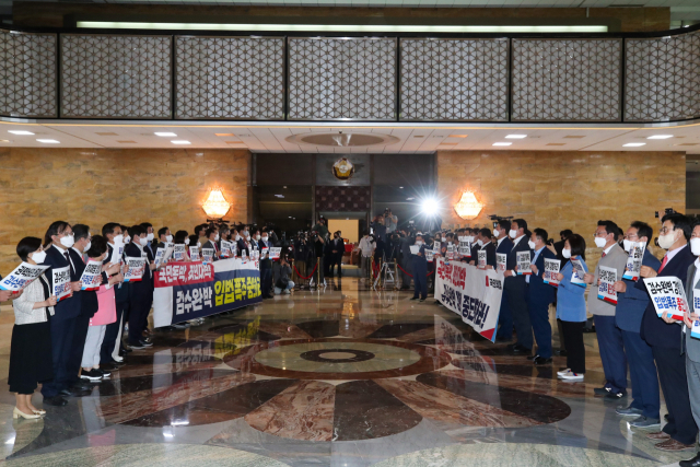 27일 국회 로텐더홀에서 국민의힘 의원들이 본회의장으로 입장하는 더불어민주당 의원들을 향해 검찰 수사권과 기소권 분리 법안 반대 구호를 외치고있다. 연합뉴스