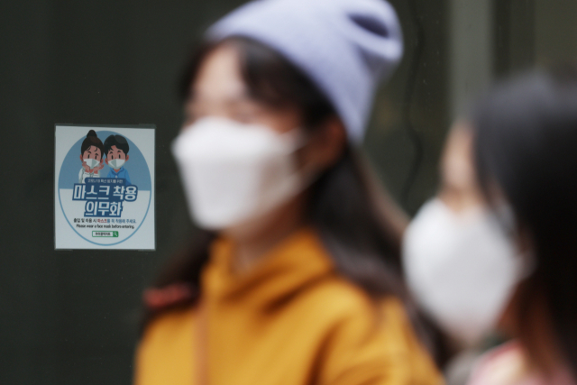 27일 오후 서울 중구 명동거리의 한 매장에 붙은 마스크 착용 의무화 안내문. 연합뉴스