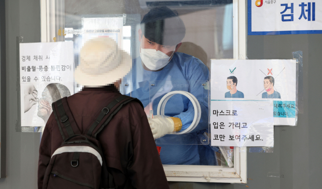 어린이날인 5일 서울역 광장에 마련된 코로나19 임시 선별검사소에서 의료진이 검체를 채취하고 있다. 연합뉴스