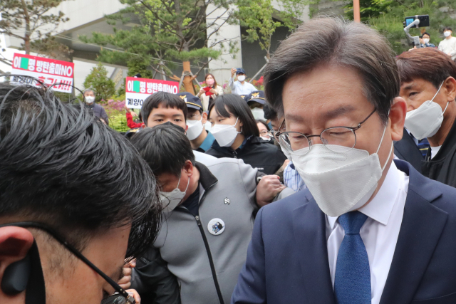 8일 인천 계양산 야외공연장에서 열린 더불어민주당 이재명 상임고문 계양을 보궐선거 출마 선언 기자회견에서 이 후보 뒤로 출마 반대 구호 피켓을 든 국민의힘 지지자들의 모습이 보인다. 연합뉴스