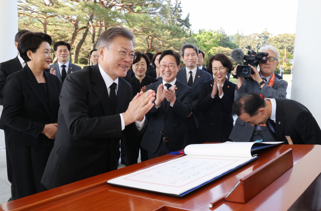 문재인 대통령이 부인 김정숙 여사와 9일 오전 서울 동작구 국립서울현충원 내 현충탑을 참배와 방명록 작성을 마친 뒤 국무위원들과 박수치고 있다. 연합뉴스
