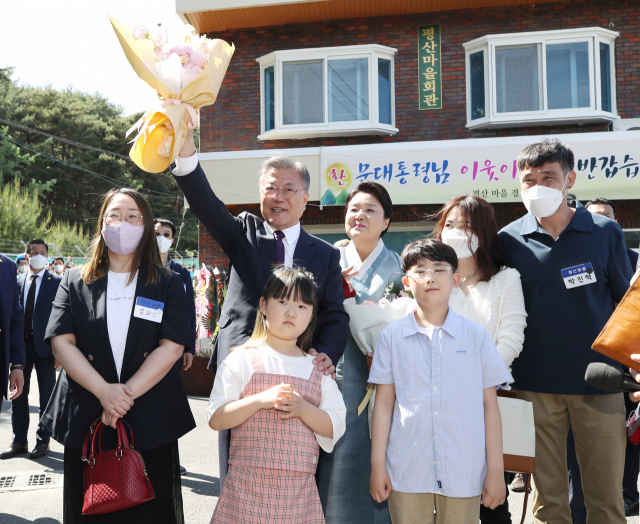 문재인 전 대통령이 10일 오후 경남 양산시 하북면 평산마을회관에서 화동들에게 꽃다발을 받은 뒤 기념 촬영하고 있다. 연합뉴스