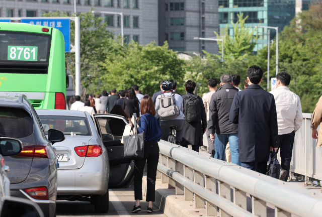 대통령 취임식으로 국회 주변 교통을 통제하고 있는 10일 서강대교 위에서 정체 중인 버스에서 시민들이 내리고 있다. 연합뉴스