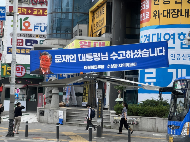11일 대구 수성구 수성시장네거리에 내걸린 문재인 전 대통령 퇴임을 기념하는 플래카드가 훼손된 채 발견됐다. 플래카드 왼편 문 전 대통령 얼굴에 빨간 페인트가 흩뿌려진 모습. 구민수 기자