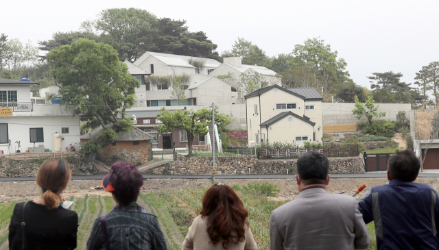 13일 경남 양산시 하북면 평산마을 문재인 전 대통령 내외 사저 맞은편 길가에 많은 사람들이 문 전 대통령 사저를 바라보고 있다. 연합뉴스