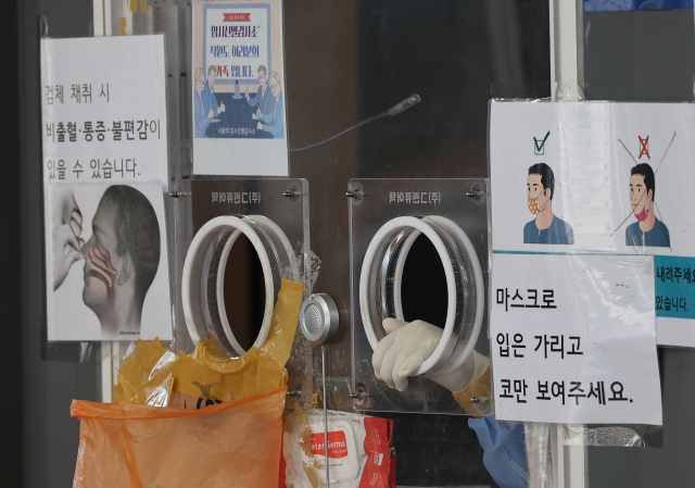 13일 서울 중구 서울역 광장 코로나19 임시 선별검사소에서 의료진이 검체 채취를 마친 뒤 대기하고 있다. 연합뉴스