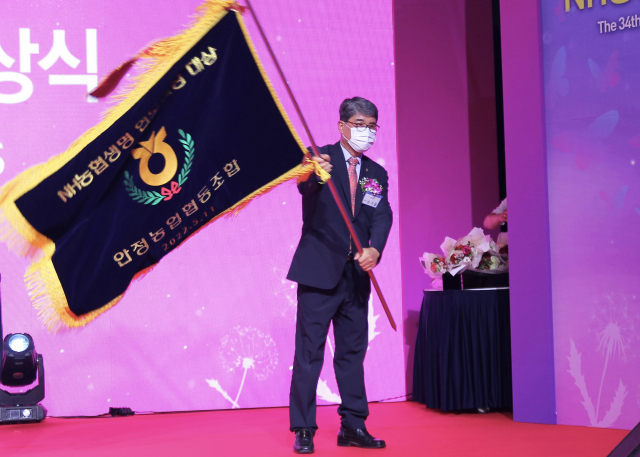 연도 대상을 수상한 손기을 안정농협 조합장이 수상기를 흔들고 있다. 안정 농협 제공