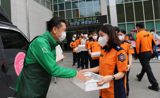 지난 13일 하이트진로 김인규 대표(왼쪽)가 강릉소방서 소방관들에 간식과 선물을 직접 전달했다.