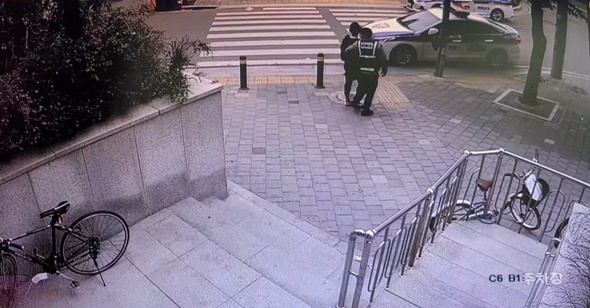 일당 중 1명이 경찰에 연행되는 모습. CCTV 갈무리